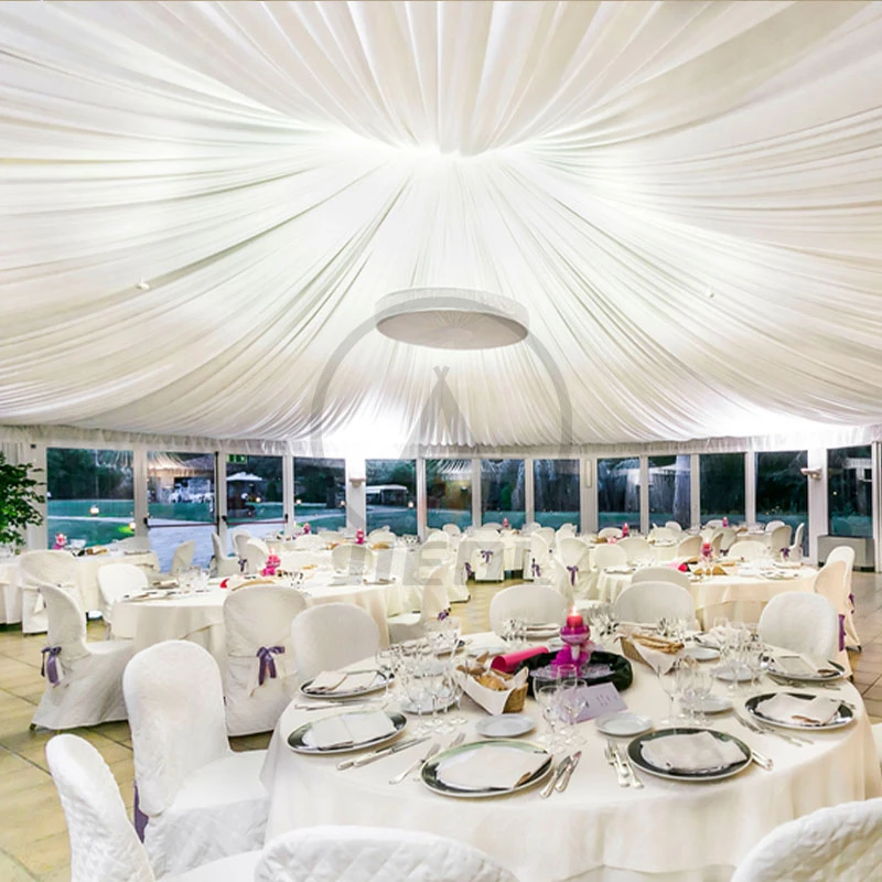Outdoor wedding reception with draped ceilings and white decor